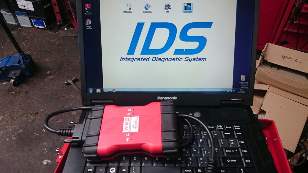 A technician connecting diagnostic equipment to a car engine in the workshop